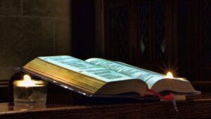 Open Bible on a wedding altar with a bouquet beside it.